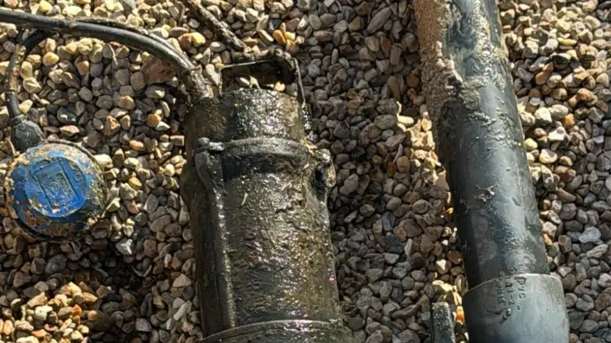 Réparer ou remplacer sa pompe de relevage : ancienne pompe de relevage sortie du poste, posée sur le gravier (photo de chantier)